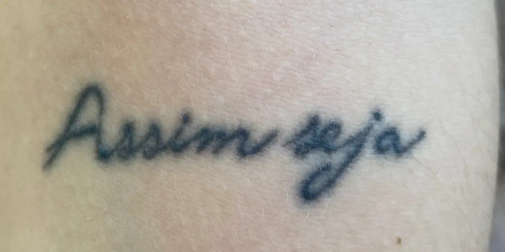 Antes: tatuagem com a escrita assim seja